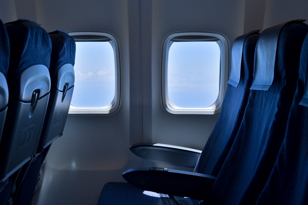 A person relaxing in a comfortable travel seat with a supportive backrest, surrounded by travel essentials.